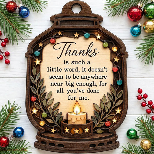 Lantern-shaped wood ornament with candle, colorful fairy lights, leafy branches, and a thank-you quote.