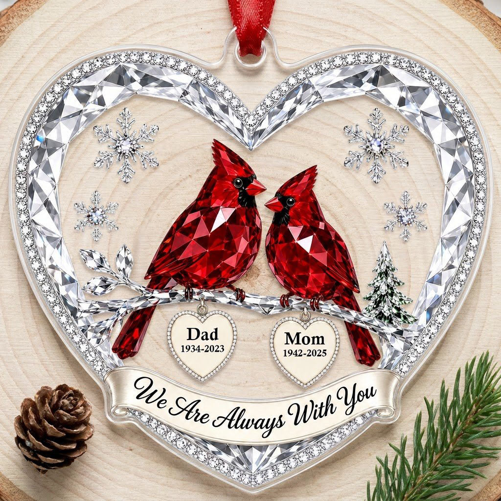 Heart ornament with two red crystal-style cardinals, snowflakes, a ribbon banner, and two dangling name-date heart charm