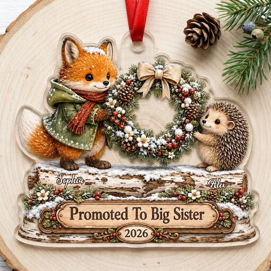 Acrylic ornament with a fox and hedgehog holding a wreath above a wood-style name banner with snowy accents.
