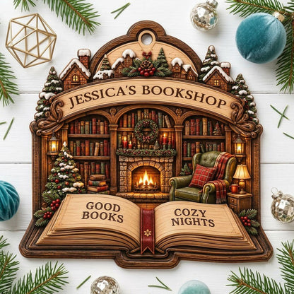 Custom-cut wood ornament with arched loop and open book base, cozy bookshop scene with tree, fireplace, armchair.