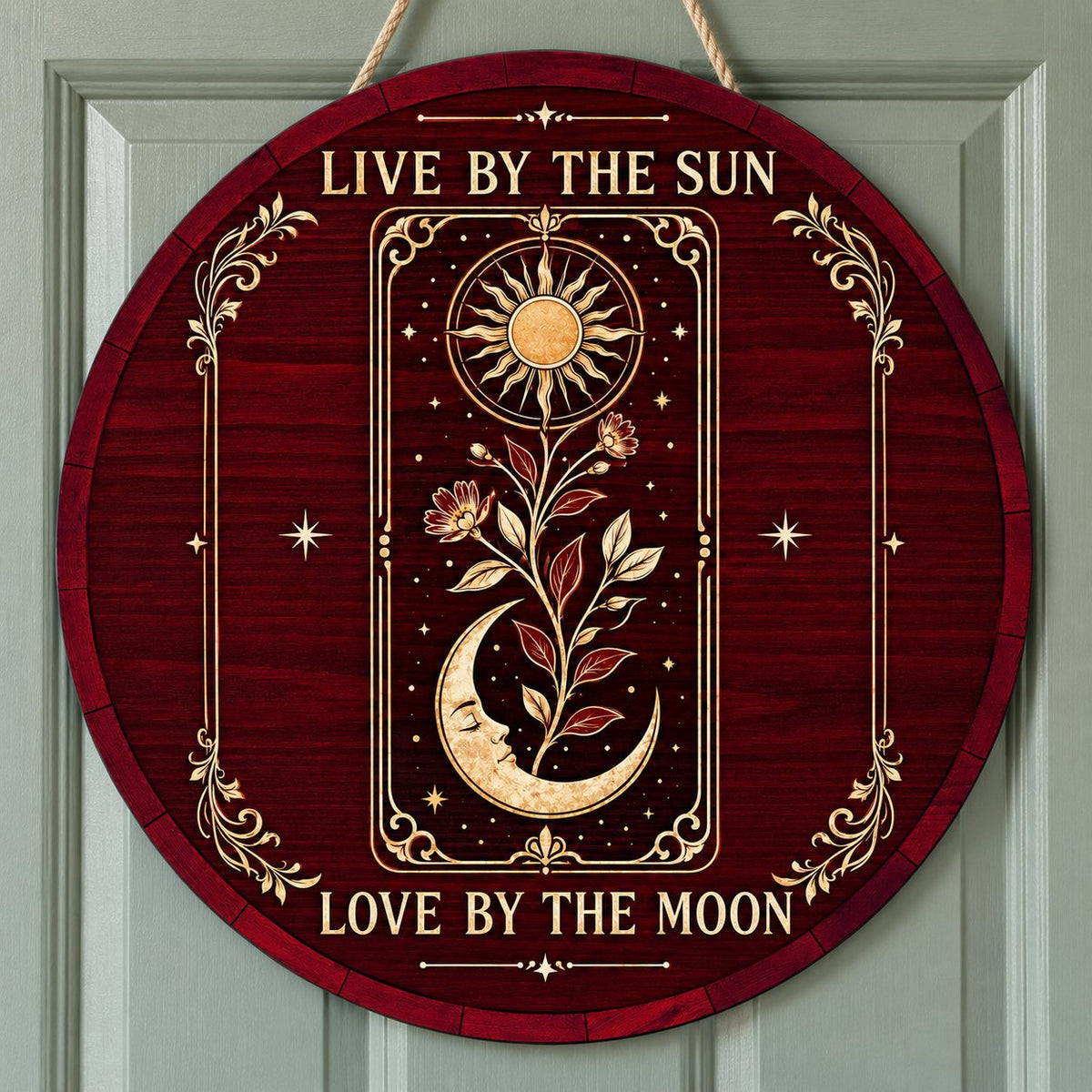 Round wooden sign with tarot-style sun and sleeping moon, floral vine, stars, and the words Live by the Sun, Love by the