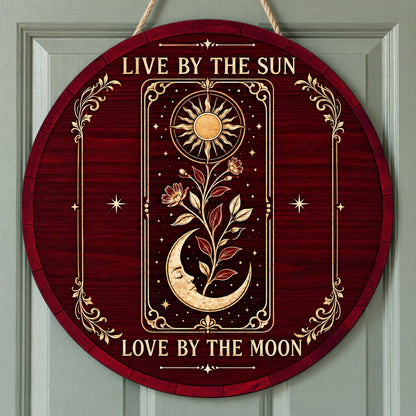 Round wooden sign with tarot-style sun and sleeping moon, floral vine, stars, and the words Live by the Sun, Love by the