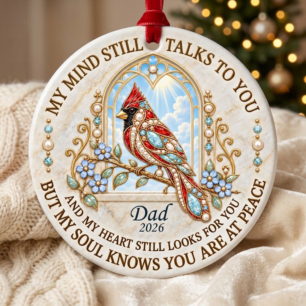 Round ceramic ornament with a red cardinal by a gold arched window, blue flowers, pearls, and a faux marble border.