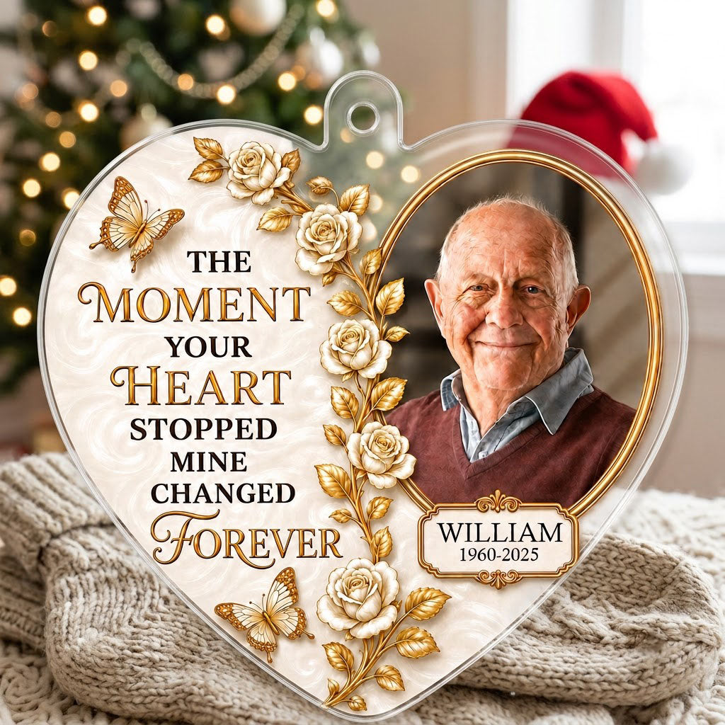 Heart-shaped acrylic ornament with a photo in a gold oval frame, white roses, gold butterflies, and a name plaque.