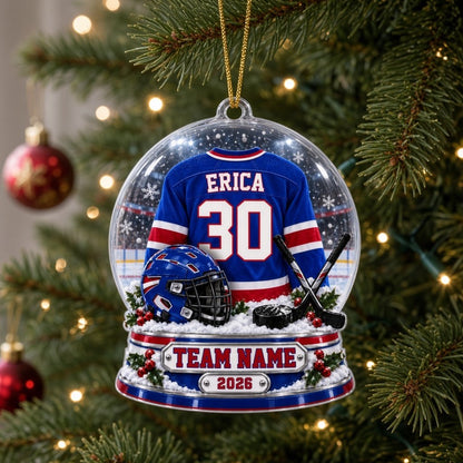 A custom-cut snow globe acrylic ornament with hockey jersey, helmet, crossed sticks, puck, and holly on the base.