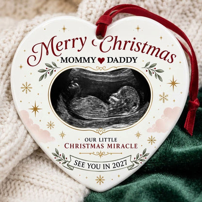 Heart ceramic ornament with ultrasound photo, gold starbursts, green leaves with red berries, and a bottom banner.