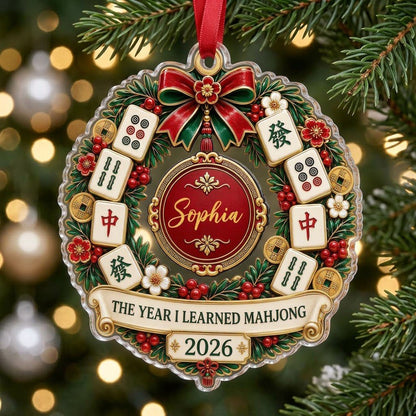 A clear acrylic wreath ornament with Mahjong tiles, red bow, gold coins, and the text THE YEAR I LEARNED MAHJONG.