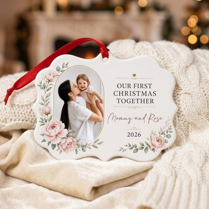 White scalloped ceramic ornament with gold oval photo frame, pink peonies, and Our First Christmas Together text.