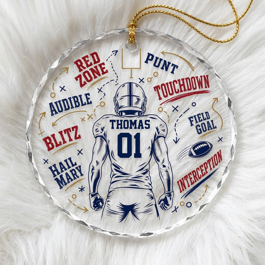 Round faceted glass ornament with football player back view, goalpost, football, and play diagrams in navy, dark red, an