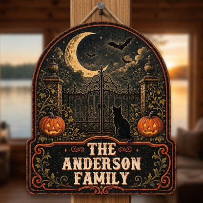 Arched wooden sign with crescent moon, bats, wrought-iron gate, black cat and jack-o'-lanterns with family name.