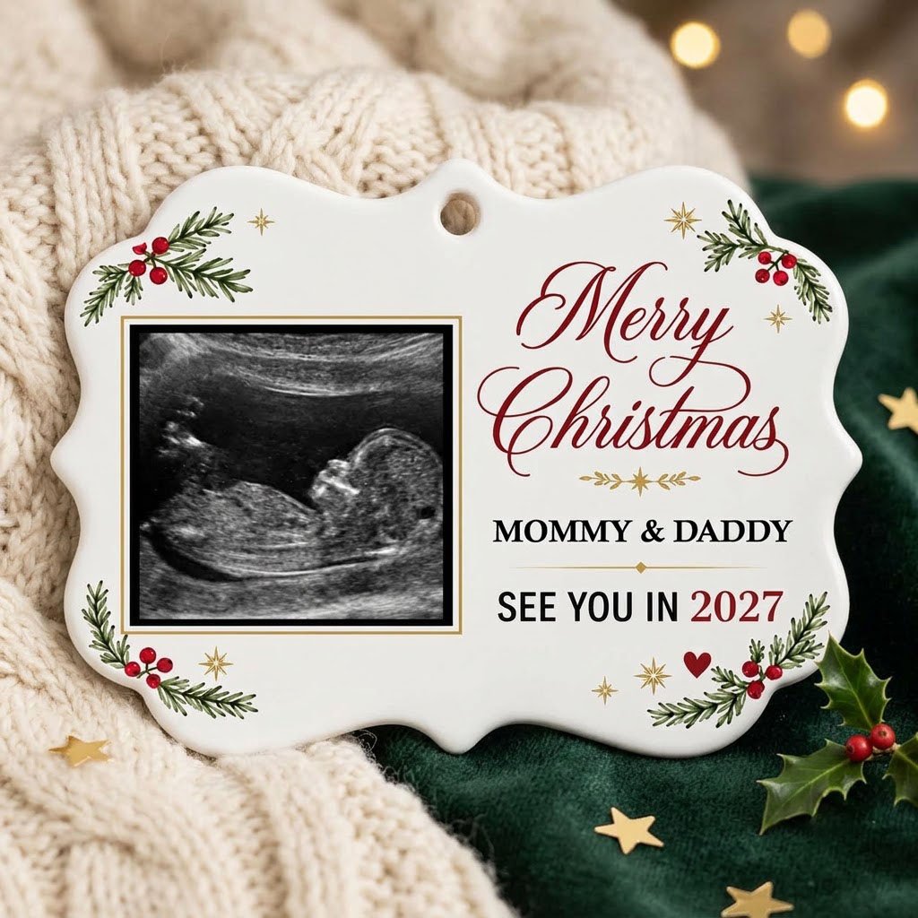 Round ceramic ornament with ultrasound photo, pine branches with red berries, gold starbursts and a red heart icon.