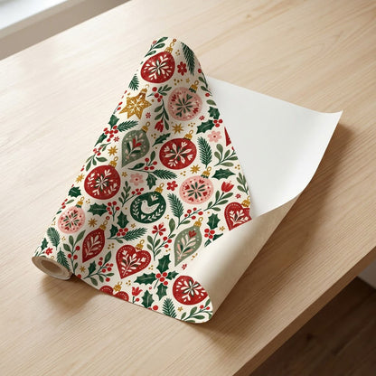 Matte wrapping paper with folk-style red, pink and green ornaments, pine branches, holly and starbursts on cream.