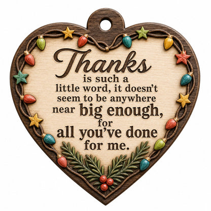 Heart-shaped wood ornament with a lights-and-stars border, pine sprigs with red berries, and a gratitude quote.