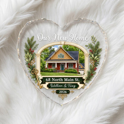 Heart glass ornament with archway, brick and yellow house, pine branches, gold key, and 'Our New Home' text.