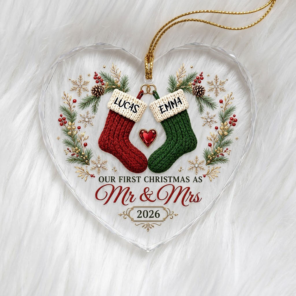 Heart-shaped glass ornament with red and green stockings hanging from gold rings and a red gemstone heart