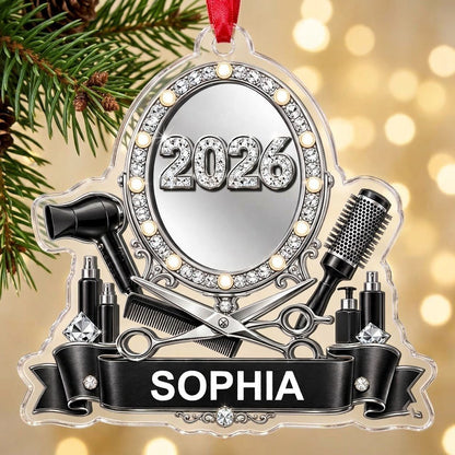 Clear acrylic ornament with a lit vanity mirror and salon tools, featuring SOPHIA and 2026 on a black banner.