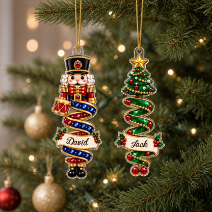 Custom-cut acrylic ornaments with a cartoon nutcracker and a praying angel wrapped in decorative ribbons.