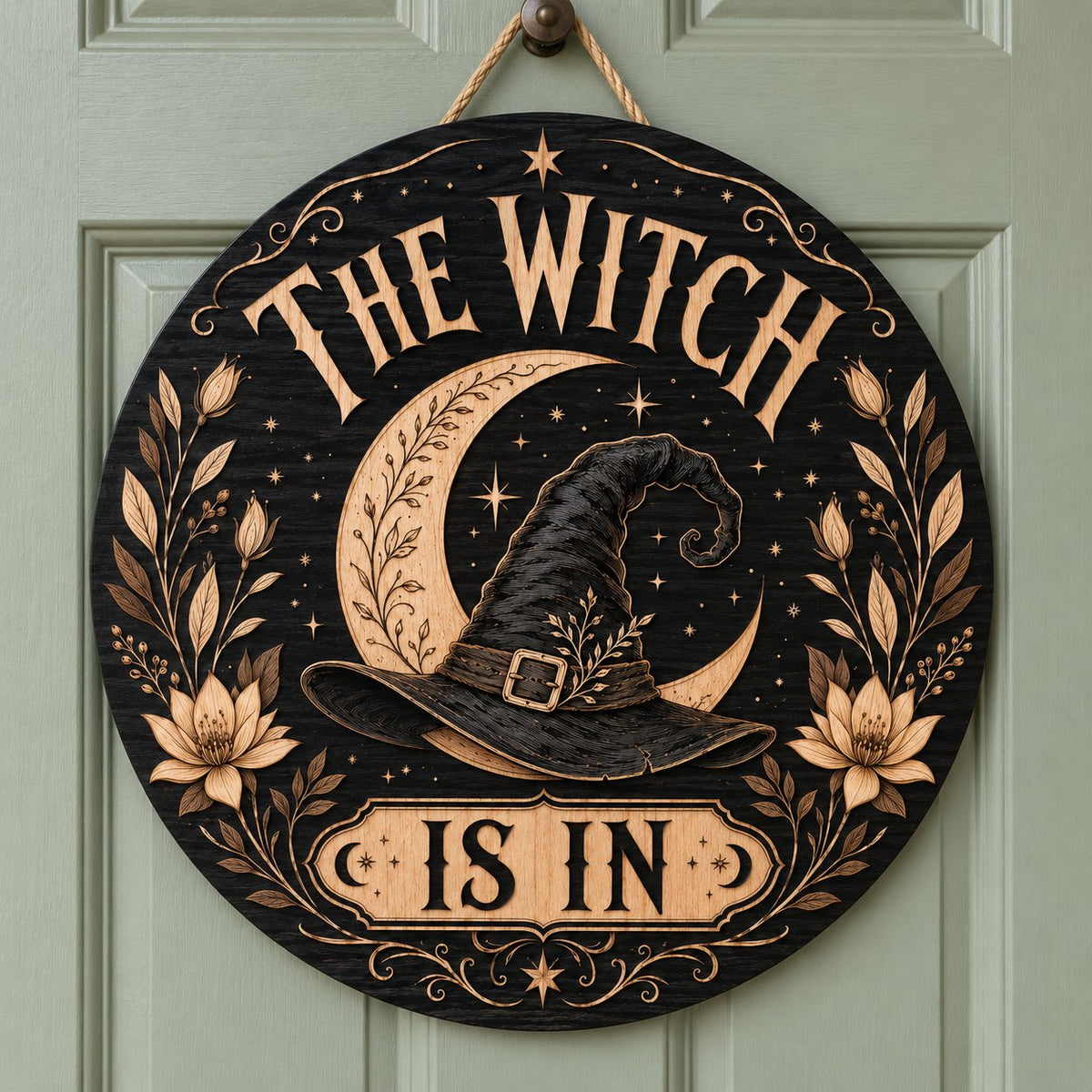 Round wooden sign with 'THE WITCH IS IN' slogan, crescent moon, witch hat, floral borders, stars and scrollwork.