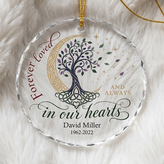 Round glass ornament with Celtic tree of life, gold crescent moon, stars, and phrase Forever loved in our hearts.