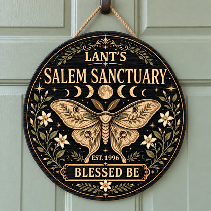 Round wooden sign with a central moth, moon phases, floral vines, stars, and 'Salem Sanctuary' 'Blessed Be' text.