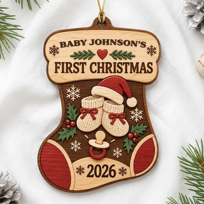 Stocking-shaped wood ornament with baby booties, Santa hat, holly, snowflakes, and FIRST CHRISTMAS text.