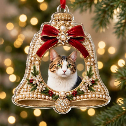Bell-shaped acrylic ornament with red velvet bow, pearl and gold accents, and a central circular photo frame.