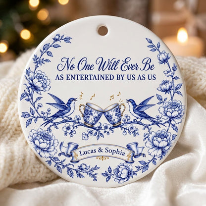 Round ceramic ornament with blue toile border, two birds, clinking floral teacups and gold music notes with two names.