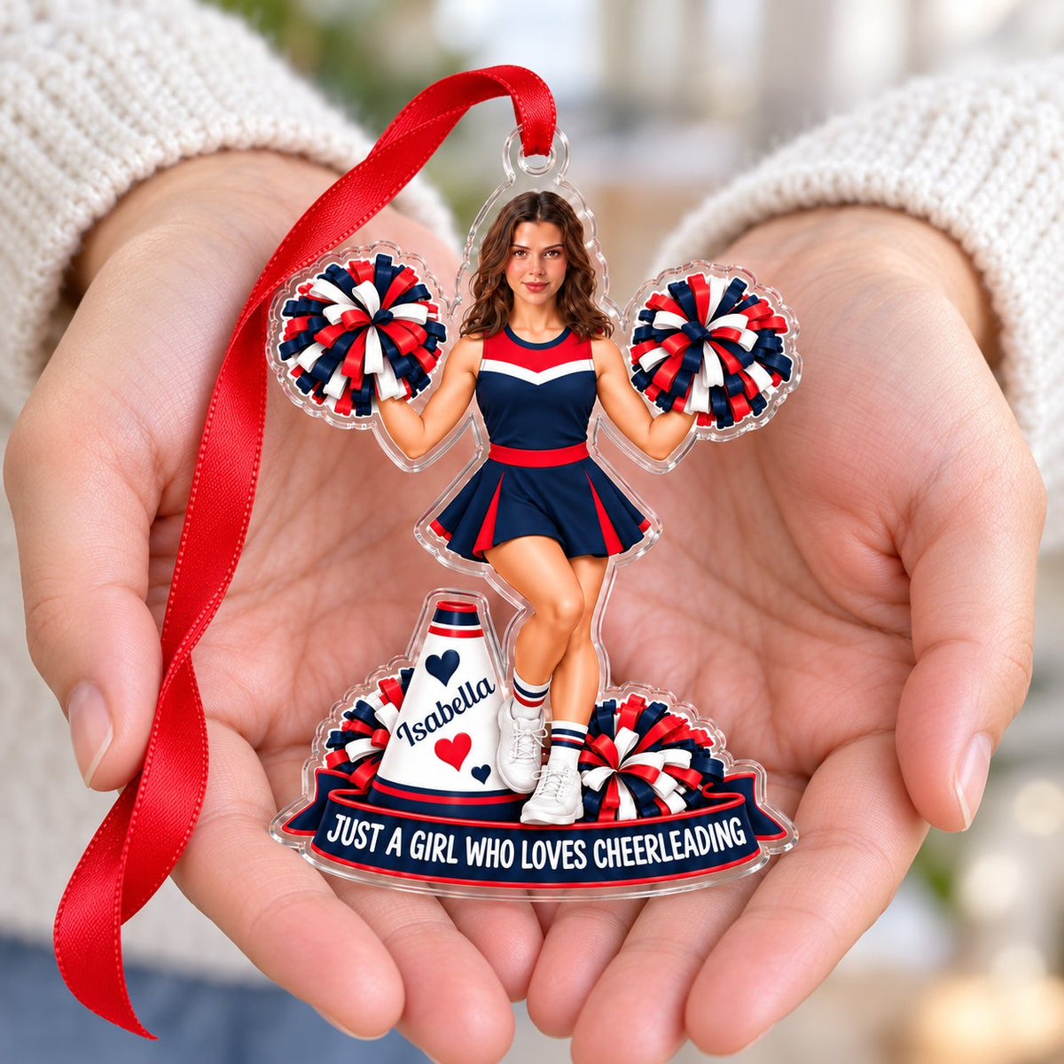Custom-cut acrylic ornament of a cheerleader in red, navy and white with pom-poms, a megaphone and a name banner.