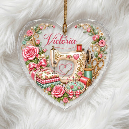Heart-shaped glass ornament with vintage cream sewing machine, pink roses, buttons, and a personalized name.