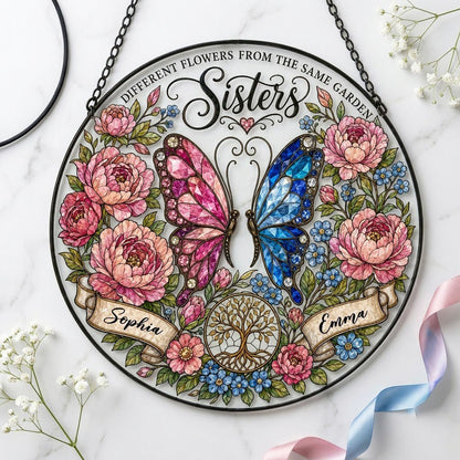 Round suncatcher with pink and blue butterfly, peony wreath, Tree of Life, and Sisters text with two name ribbons.