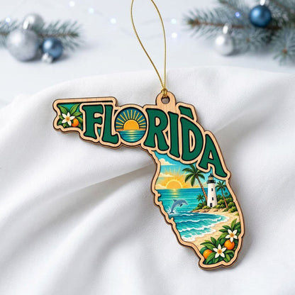 Florida state wood ornament with "FLORIDA", beach waves, dolphin, lighthouse, palm trees, and orange blossoms.