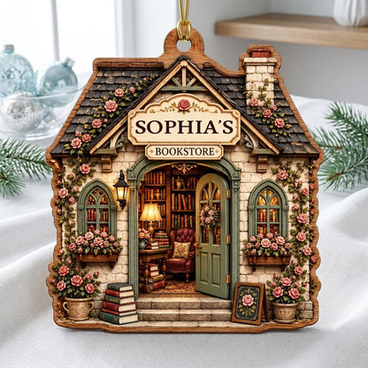 House-shaped wood ornament of a cozy bookstore with green door, rose vines, books, and a BOOKSTORE sign.