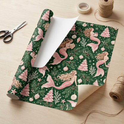 Dark green wrapping paper with pink-tailed mermaids, pink Christmas trees, starfish and snowflakes in a seamless pattern