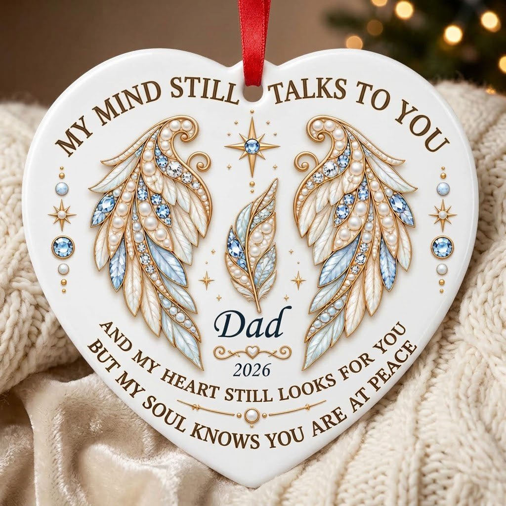 White heart ceramic ornament with jeweled angel wings, blue gems, gold scrollwork, personalized name and year.