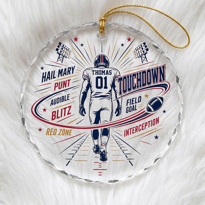 Round faceted glass ornament with football player back view, stadium lights, navy swoosh, and name and number.