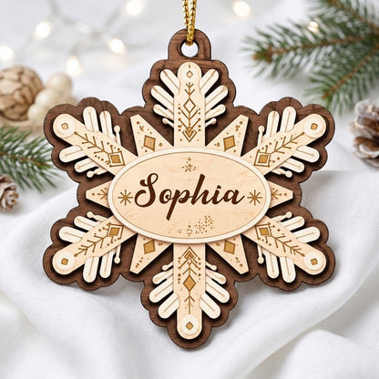 Layered wood snowflake ornament with geometric engravings and a central oval name plate for a custom name.