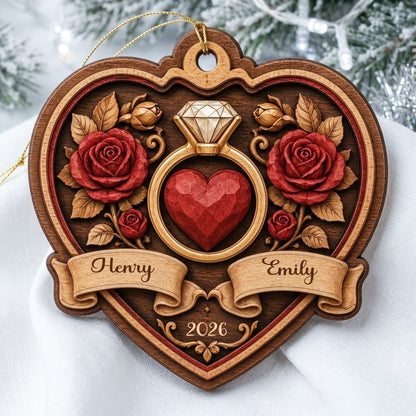 Heart-shaped wood ornament with a gold ring, red heart, red roses, and names Henry and Emily with year 2026.
