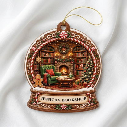 Snow globe ornament with candy-cane frame, cozy book-filled library, fireplace, tree, and 'JESSICA'S BOOKSHOP' nameplate