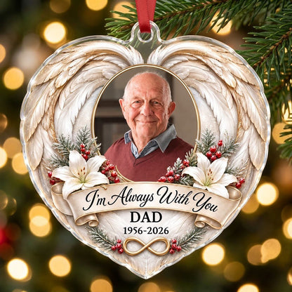 Heart-shaped acrylic ornament with angel wings, oval photo frame, white lilies, pine sprigs, red berries, and 'I'm Alway