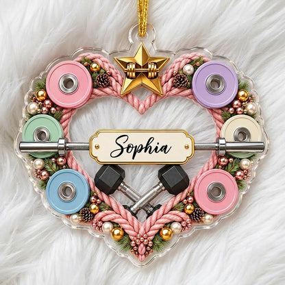 Clear acrylic heart ornament with pink rope wreath, pastel plates, barbell, crossed dumbbells, and a name plaque.