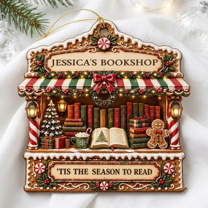 Gingerbread bookstore facade ornament with striped awning, wreath, books, lanterns, and 'TIS THE SEASON TO READ' text.