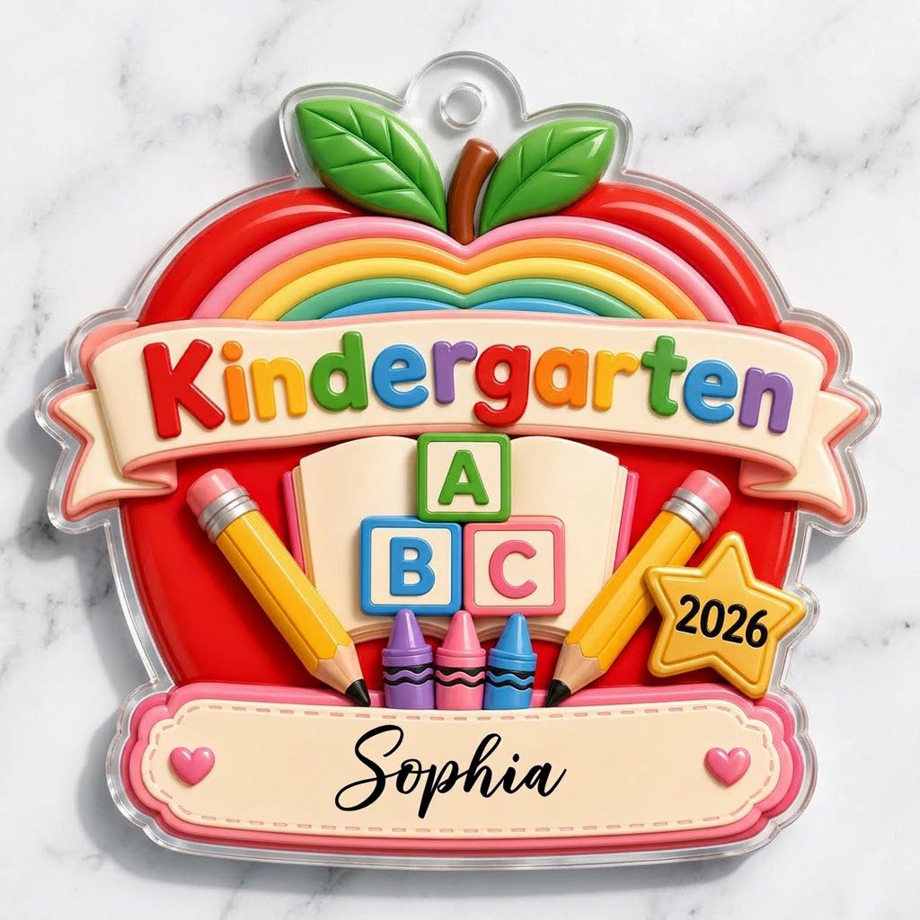 Red apple acrylic ornament with 'Kindergarten 2026', rainbow, ABC blocks, crayons, pencils, star badge, and a name banne
