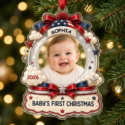 Custom-cut acrylic ornament with baby's photo, patriotic beanie, red bows, stars, and 'Baby's First Christmas' banner.