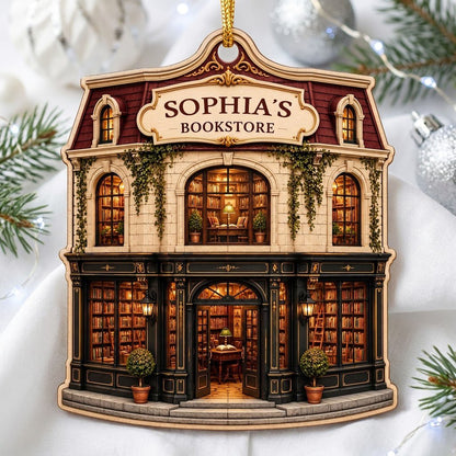 Custom-cut ornament shaped like a vintage bookstore with green and gold storefront and 'BOOKSTORE' text personalized abo