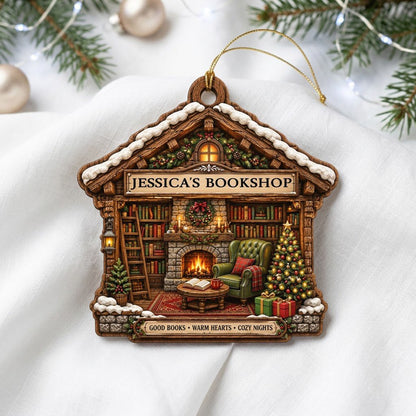 House-shaped wood ornament with cozy bookshop scene, fireplace, bookshelves, and a lit Christmas tree.