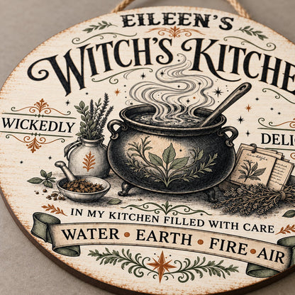 Round wooden hanging sign with a bubbling cauldron, herbs, spellbook, stars and the words Witch's Kitchen.