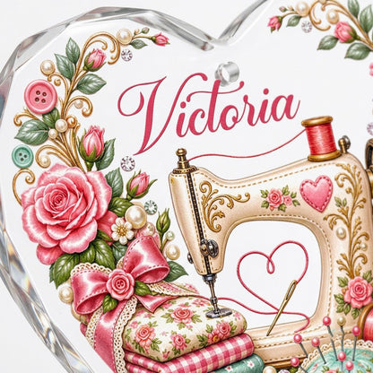 Heart-shaped glass ornament with vintage cream sewing machine, pink roses, buttons, and a personalized name.