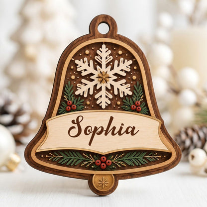 Personalized wooden bell ornament with snowflake, pine sprigs, red berries, and a name on the center banner.