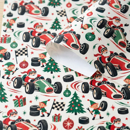 Cream wrapping paper with Santa driving vintage race cars, elves with tools and flags, trees, gifts, tires, and stars.