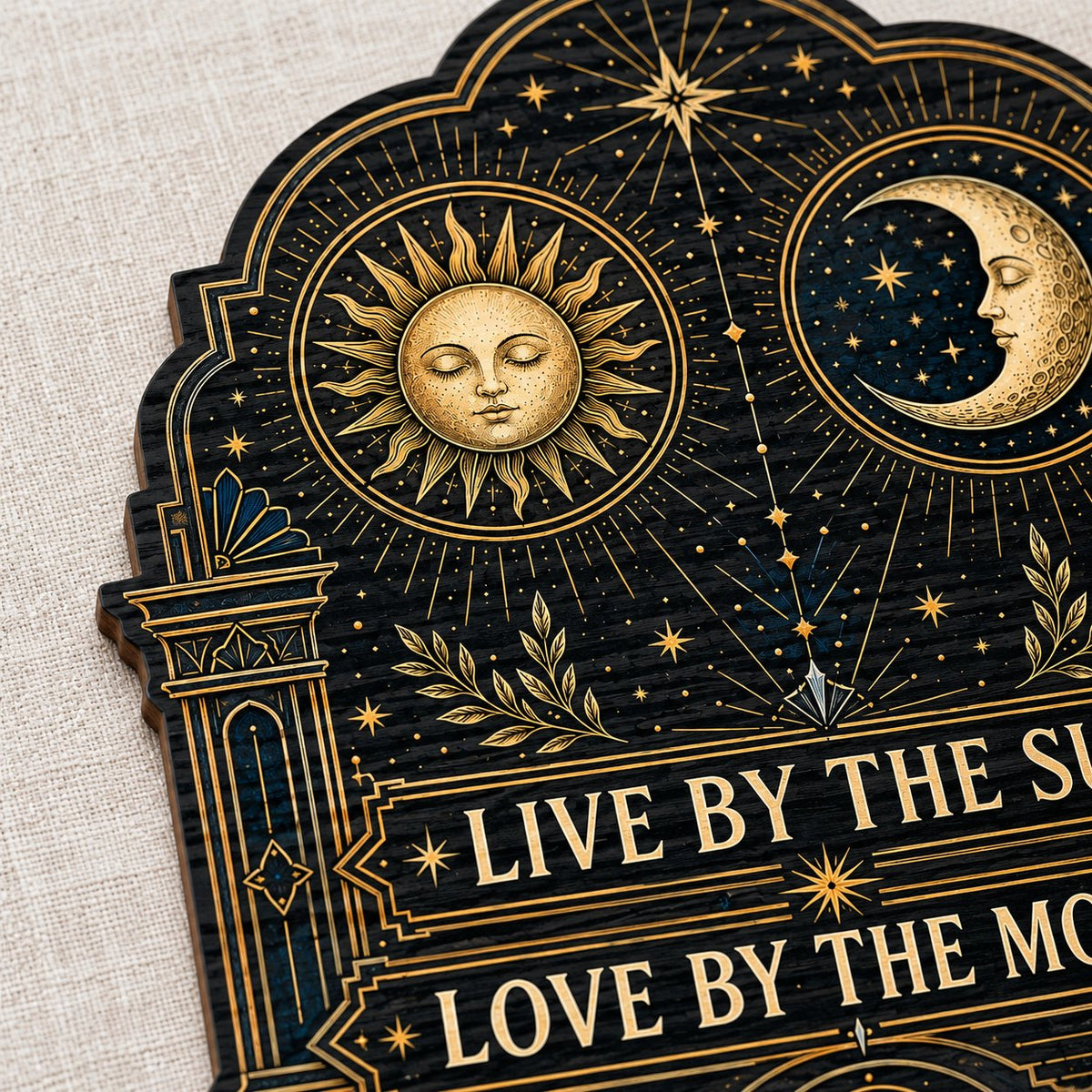 Arched wooden sign with sun and moon faces, constellations, and 'Live By The Sun, Love By The Moon'.